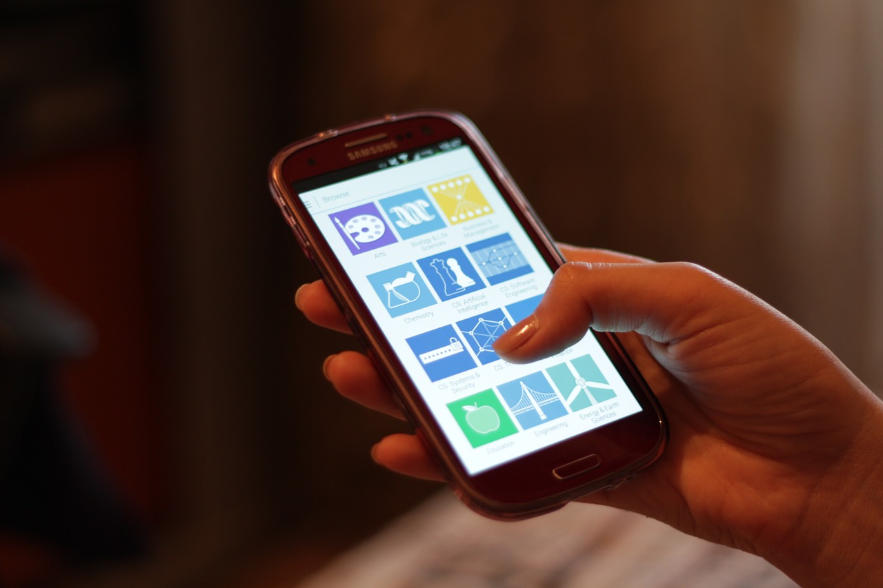 Seorang pengguna memegang dan mengoperasikan telepon pintar